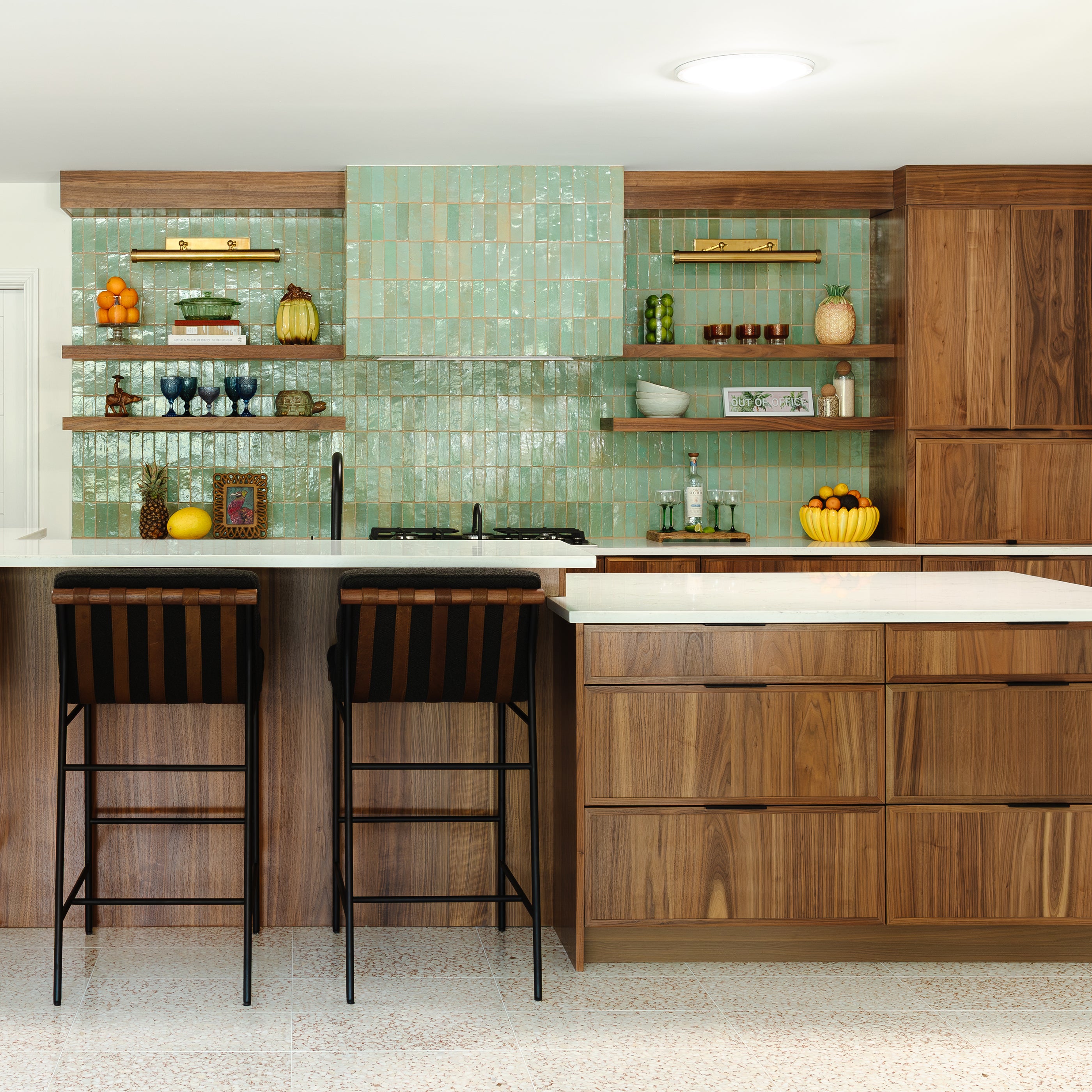 Modern kitchen with wooden cabinets, zellige green backsplash, and white countertops.