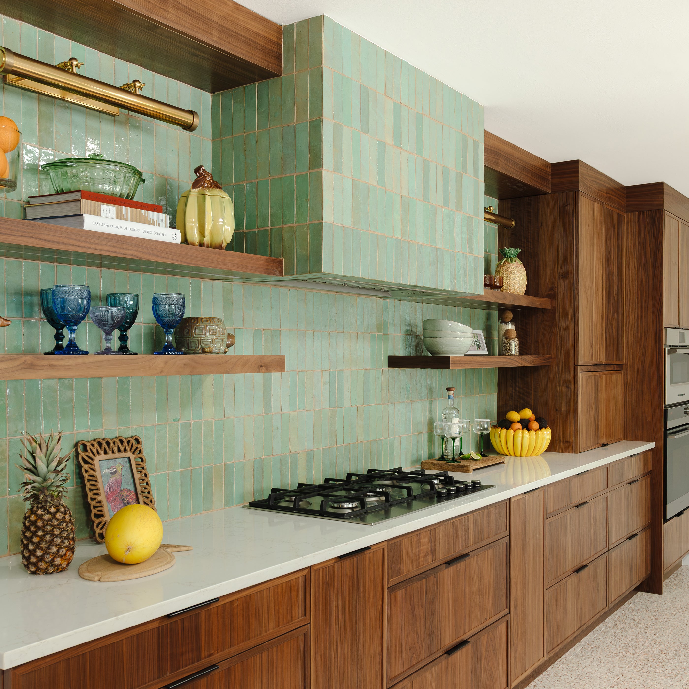 Modern kitchen with wooden cabinets, zellige green tiled backsplash, and white countertops.