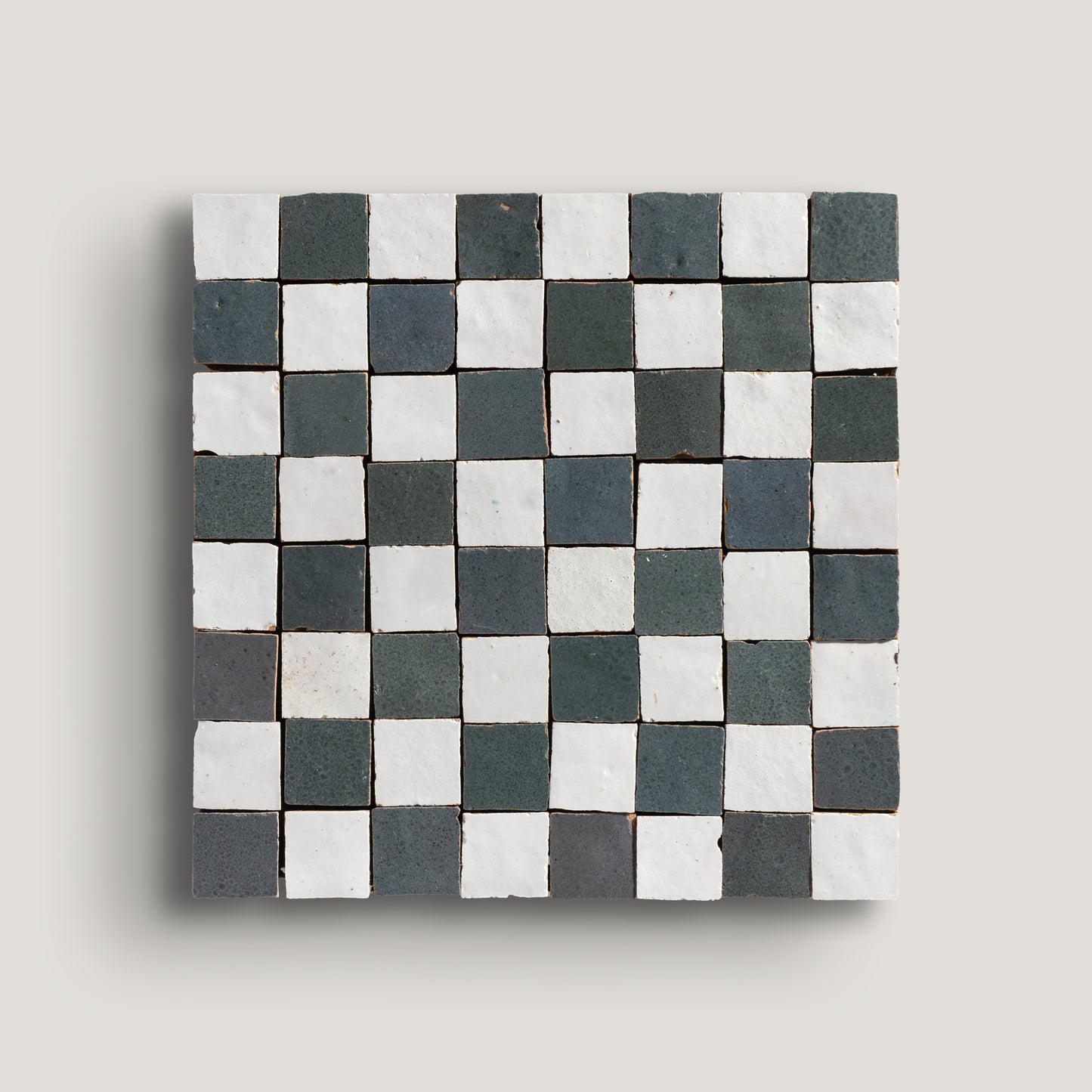 white and grey small square checkerboard zellige tile on a light grey background