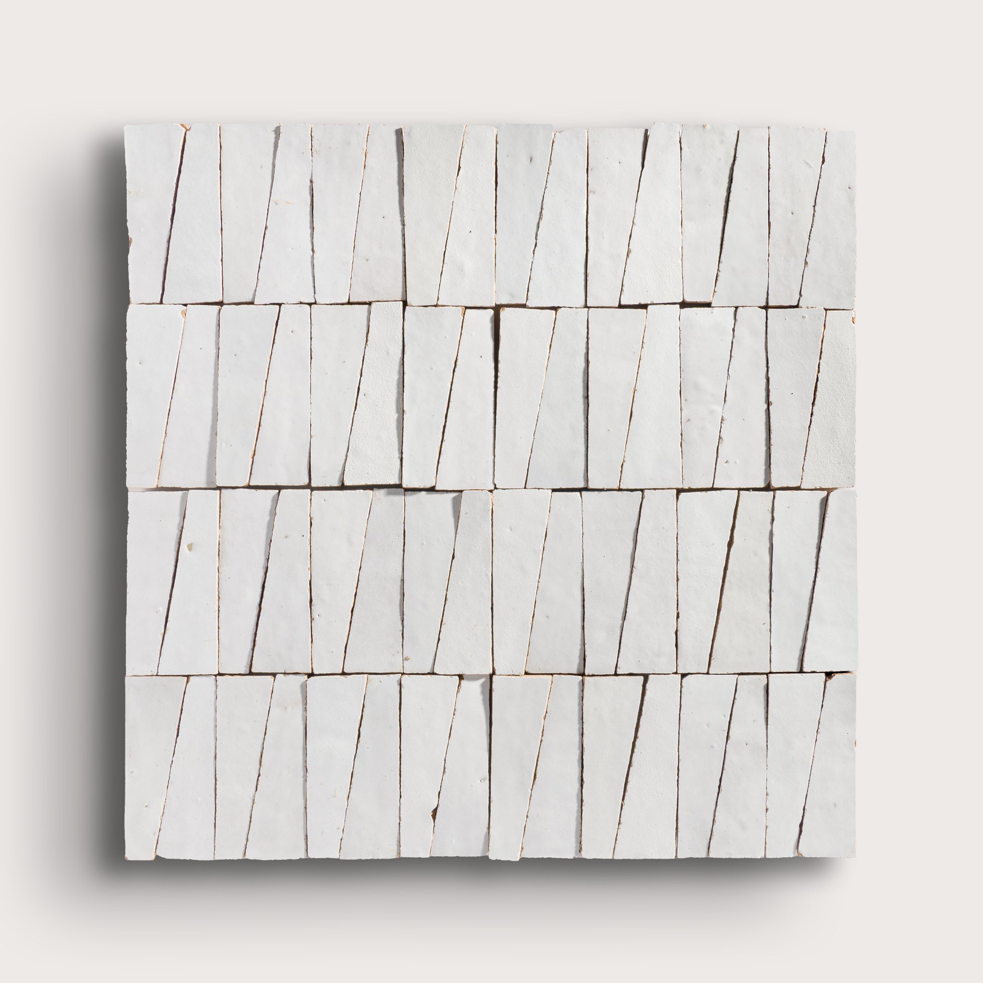 snow white trapezoid zellige tile on a light grey background