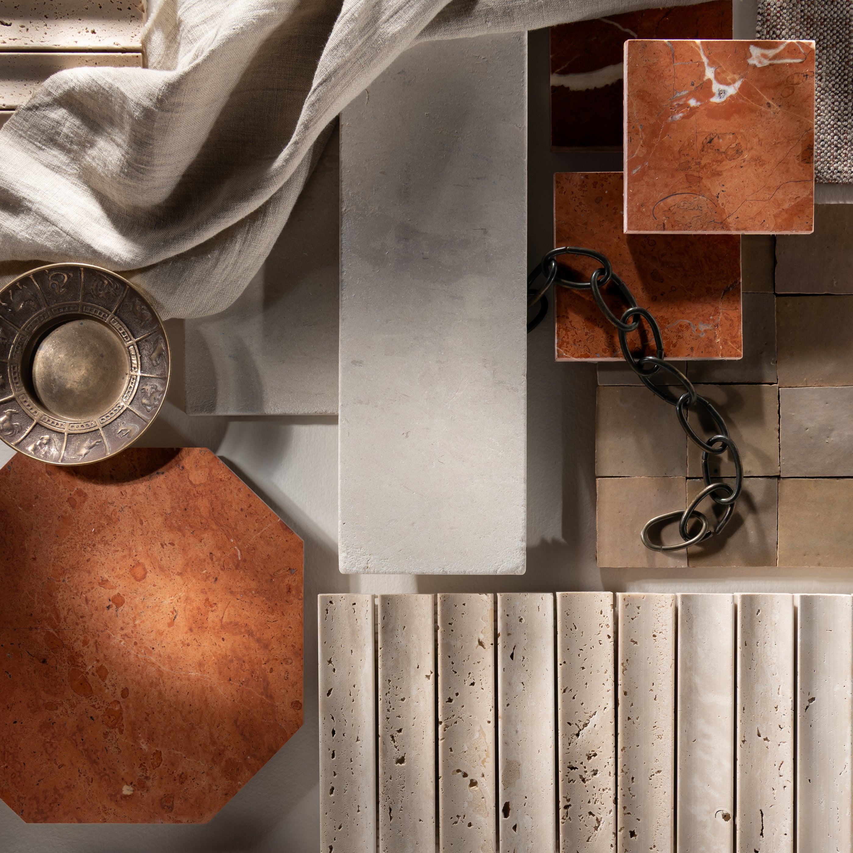 Collage of architectural elements including limestone and marble, metal chains, and decorative items on a textured surface.