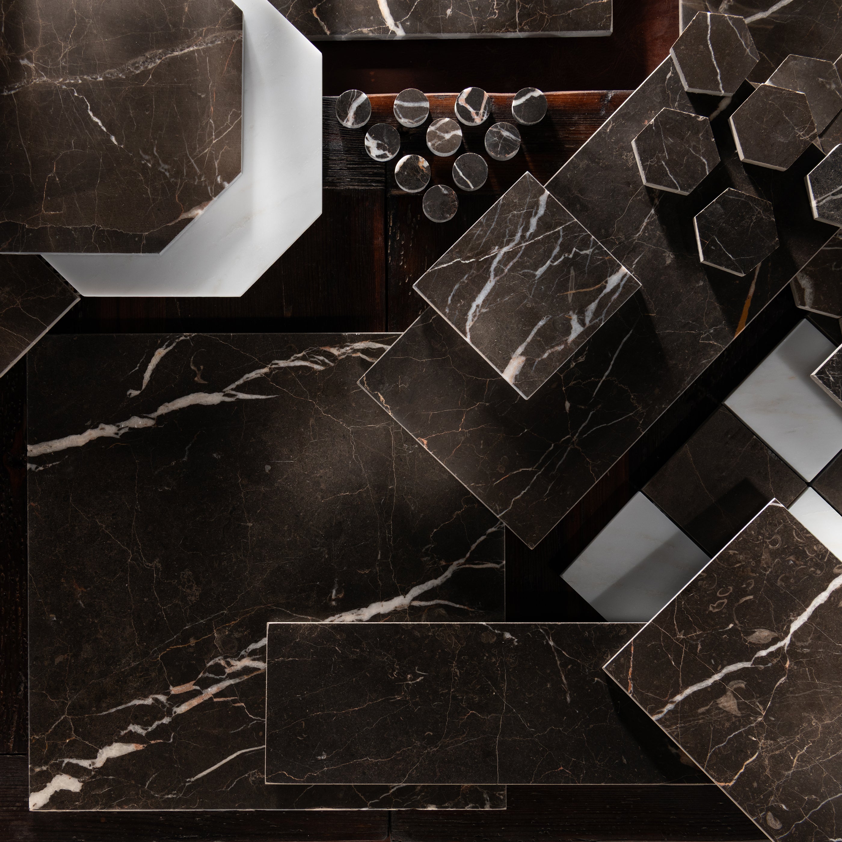 Collection of dark marble tiles with varying patterns and sizes.