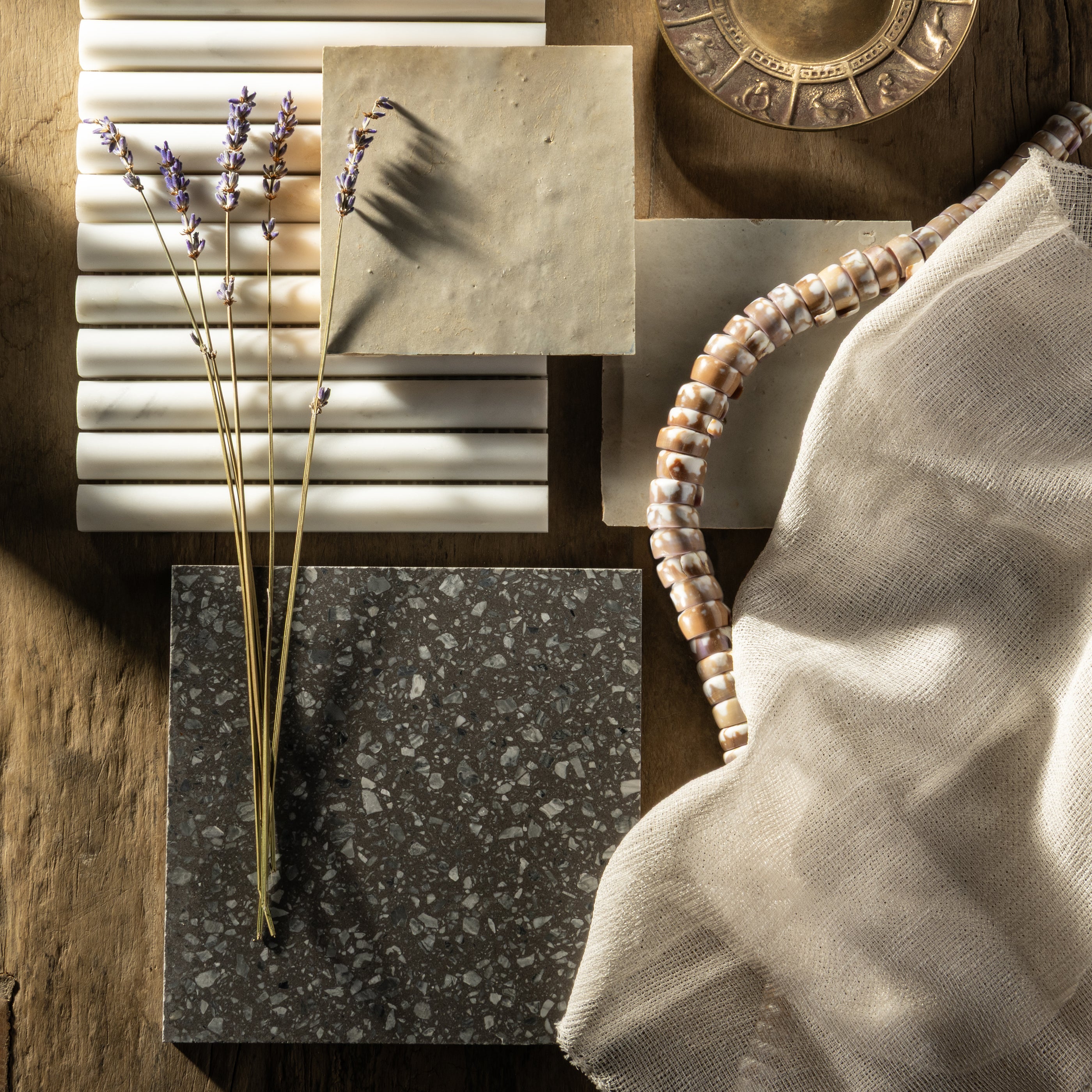 Collection of terrazzo tiles with various patterns and colors on a wooden surface.