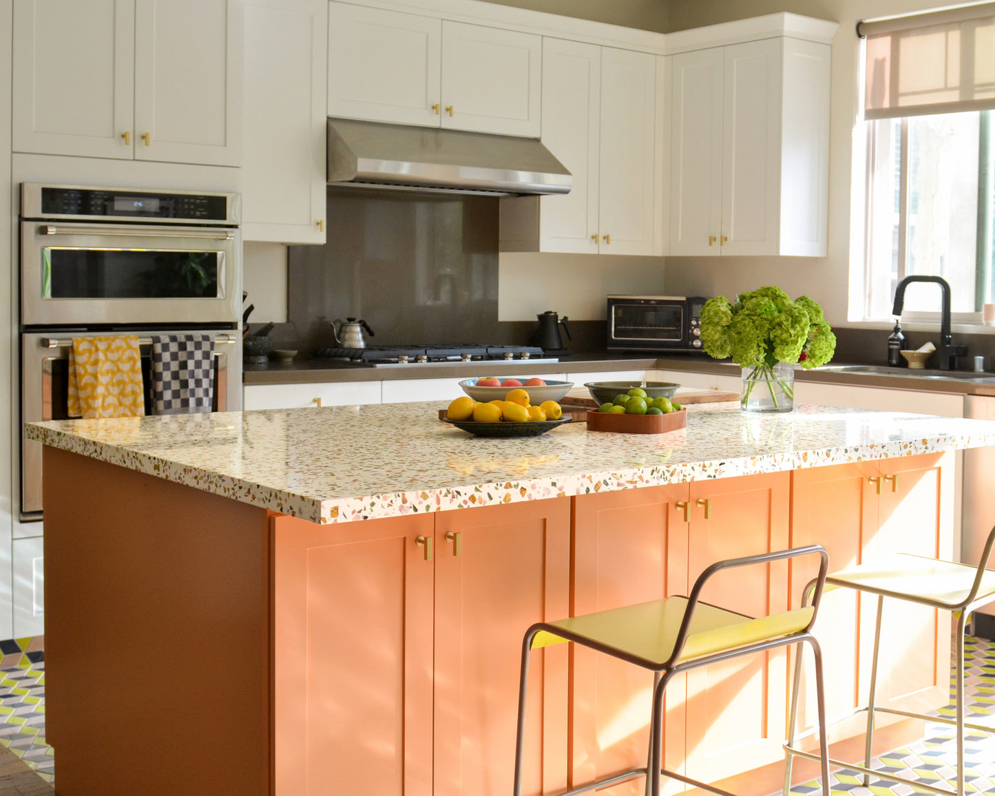 Modern kitchen with a breakfast bar with a terrazzo slab, appliances, and decorative elements.