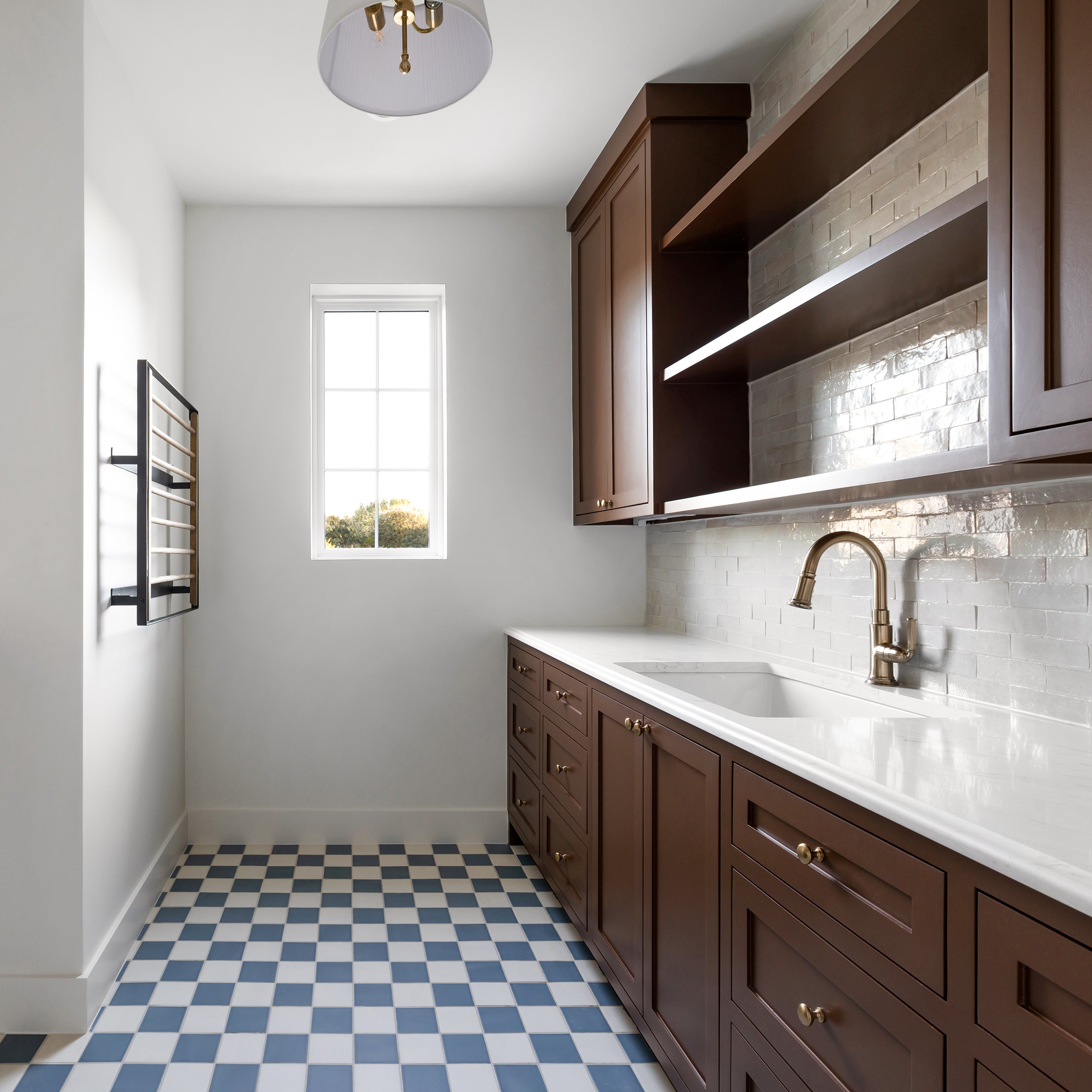 Modern laundry room with wooden cabinets, white countertop, and checkered ceramic floor.
