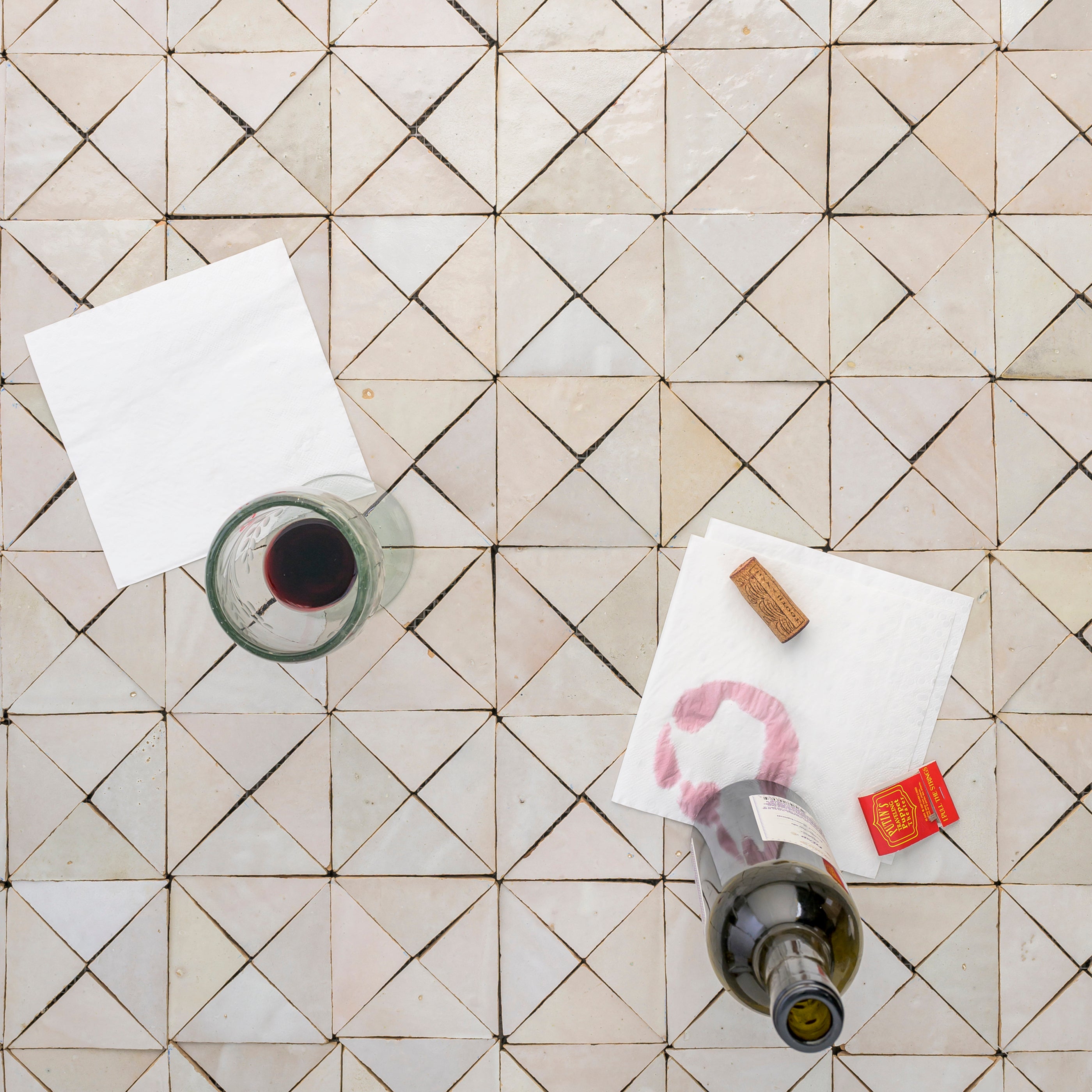 Wine bottle with cork and glass on a zellige tiled floor