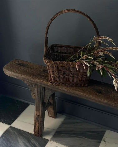 woven basket on wooden bench and marble checkerboard flooring