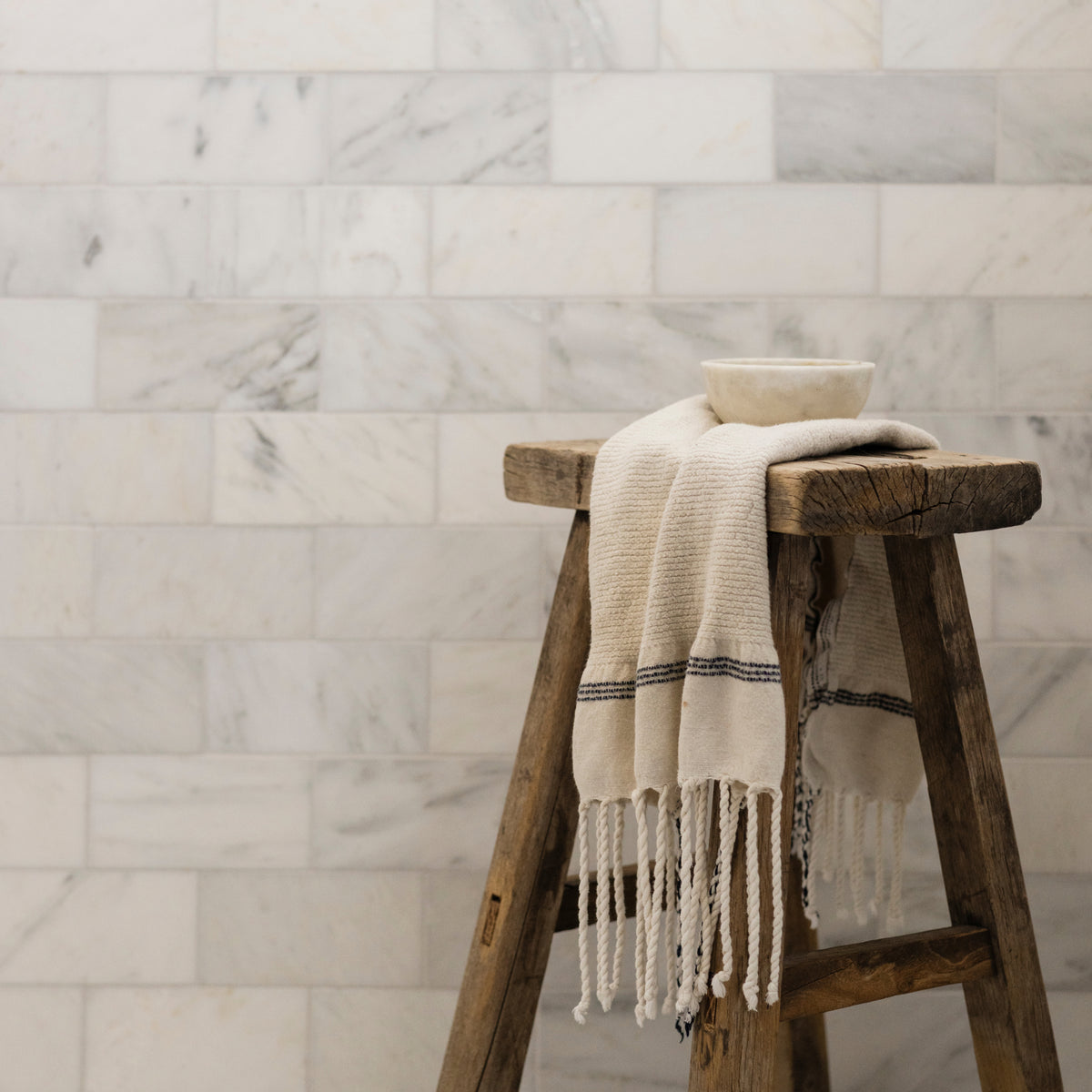 marble tile in shower with wooden stool